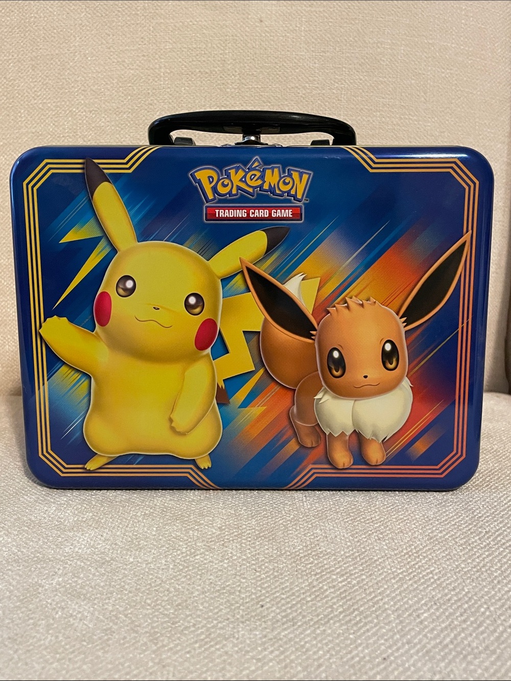 Pokemon Tin Featuring Pikachu (Yellow) & Eevee (Brown) on Blue Background